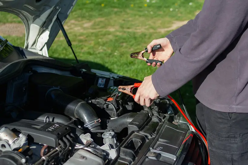 Connecting jump leads over an open bonnet at the roadside